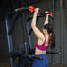 Body-Solid Proclub Vertical Knee Raise SVKR1000BX Woman doing a pull-up using wide grip handles with red grips on a power tower.