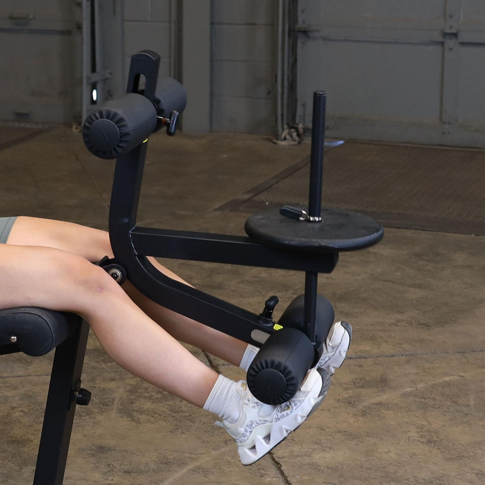 Body-Solid Seated Leg Extension & Supine Curl GLCE365B Close-up of foot rollers and weights on leg extension arm