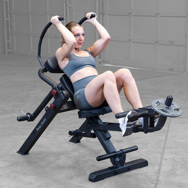Body-Solid Semi-Recumbent Ab Bench GAB300B Woman in the extended position during a weighted ab crunch on exercise machine