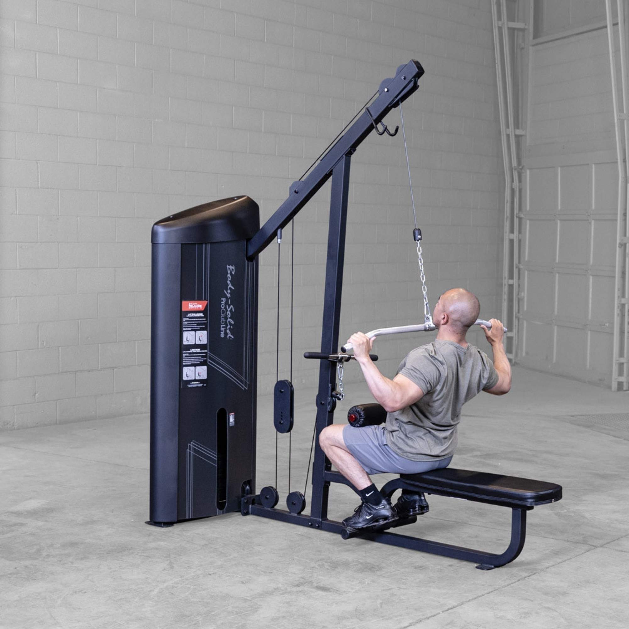 Body-Solid Series 2 Lat Mid Row S2LATX  Man seated on Body-Solid ProClub Line lat pulldown machine performing a wide-grip pulldown exercise with back muscles engaged