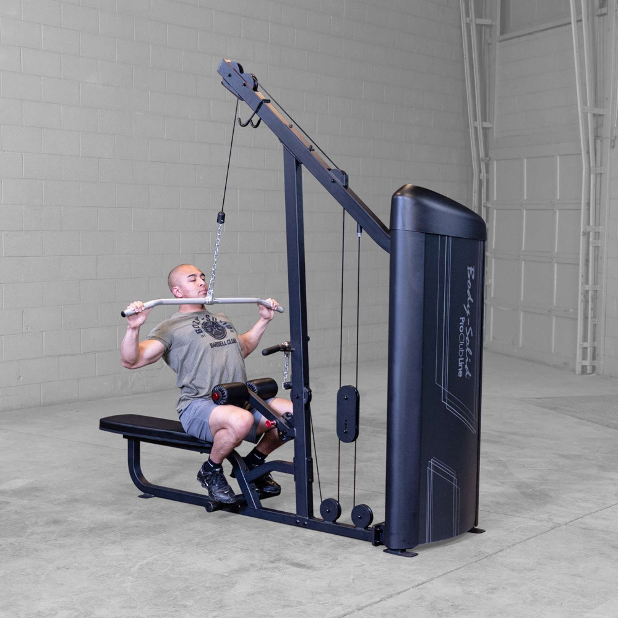 Body-Solid Series 2 Lat Mid Row S2LATX  Man using Body-Solid ProClub Line lat pulldown machine in a commercial gym setting, pulling bar down during exercise