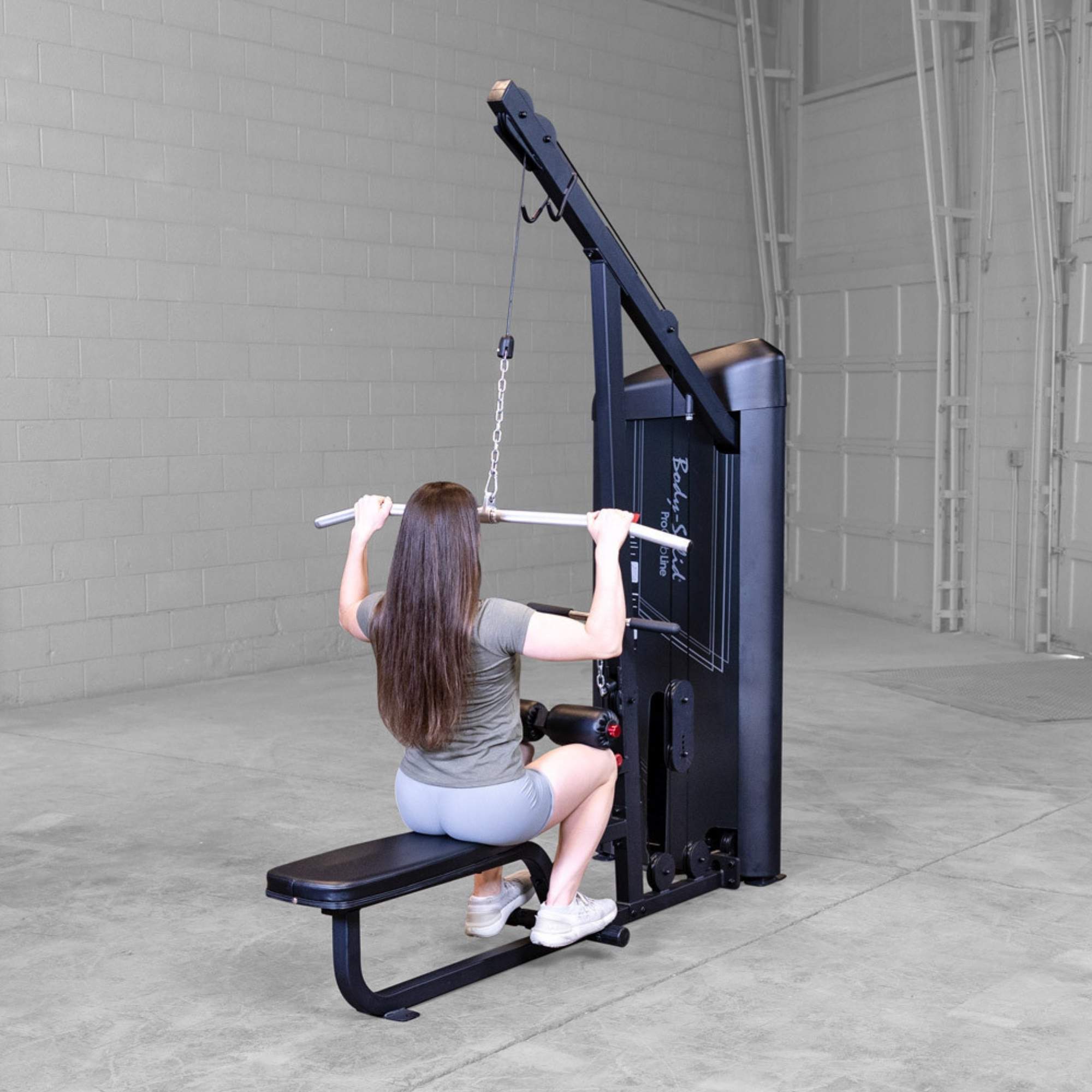Body-Solid Series 2 Lat Mid Row S2LATX  Woman performing lat pulldown exercise from behind on Body-Solid ProClub Line weight-stack machine with padded suppor