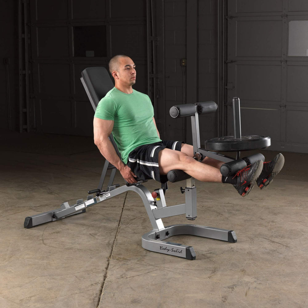 Body-Solid Series 7 Smith Machine Gym Package GS348QB4 Man doing leg extension exercise using Body-Solid leg developer attachment