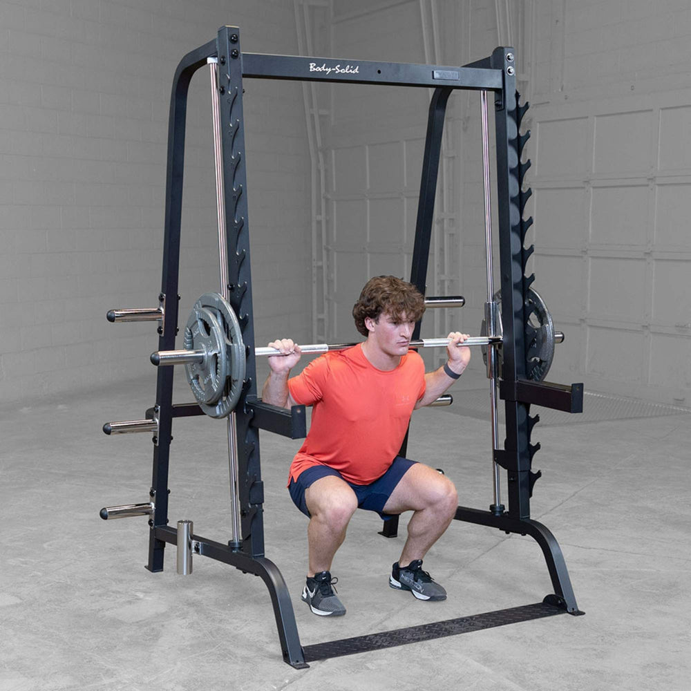 Body-Solid Series 7 Smith Machine Gym Package GS348QB4 Man performing barbell back squat inside Body-Solid Smith machine