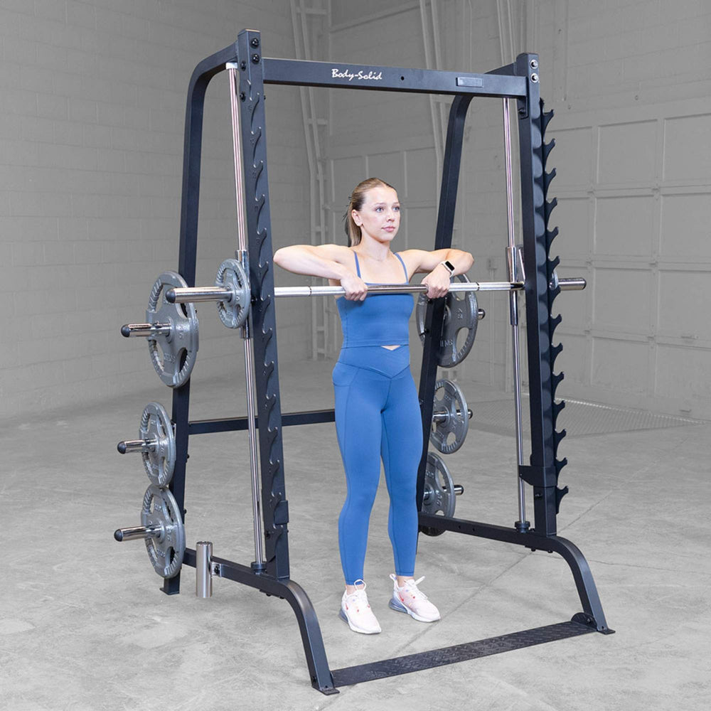 Body-Solid Series 7 Smith Machine Gym Package GS348QB4 Woman performing upright row using Smith machine inside Body-Solid gym rack