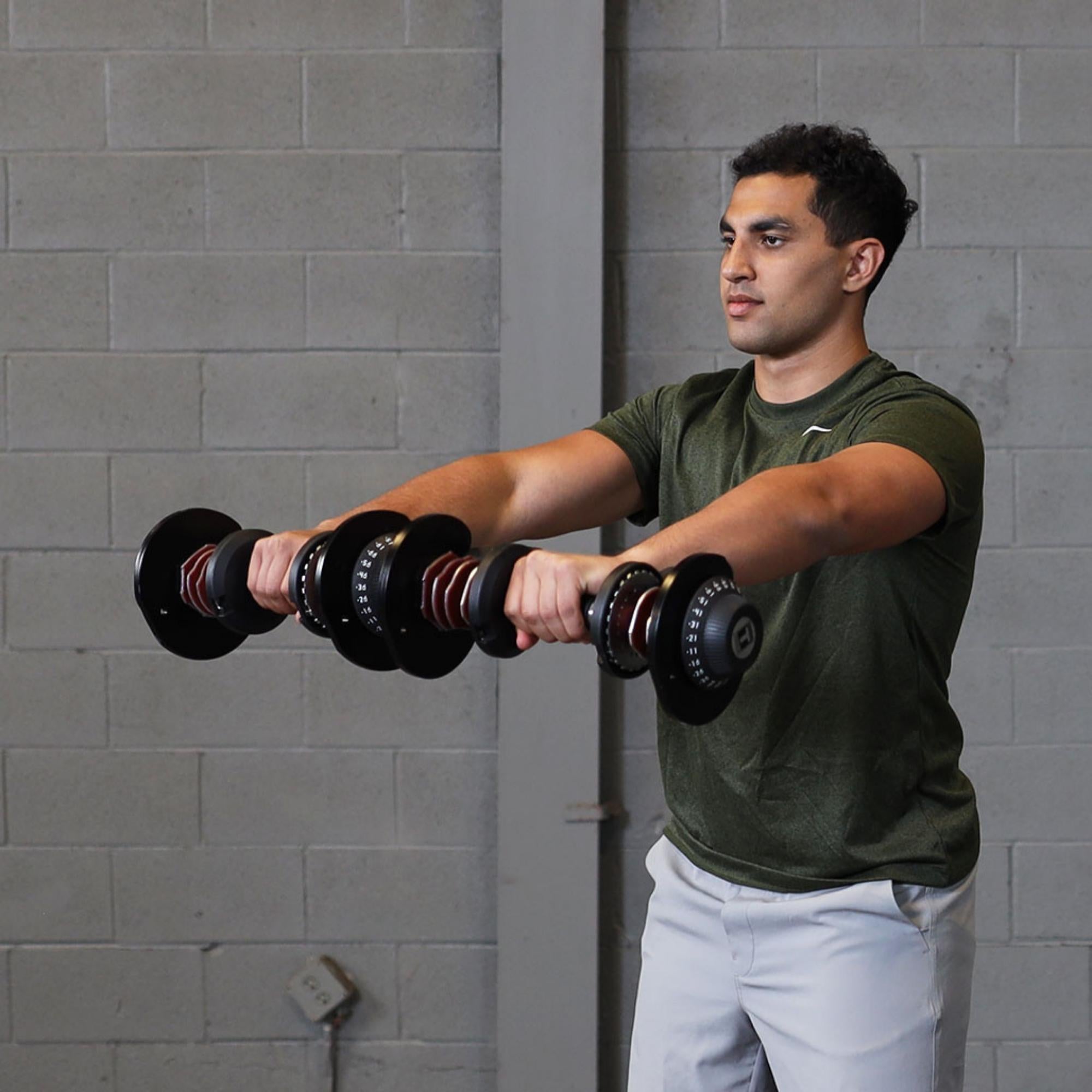 Body-Solid Tools Adjustable Dumbbell Set, 11 lb. to 66 lb. with Stand SDBX132ST Man performing front raises with adjustable dumbbells