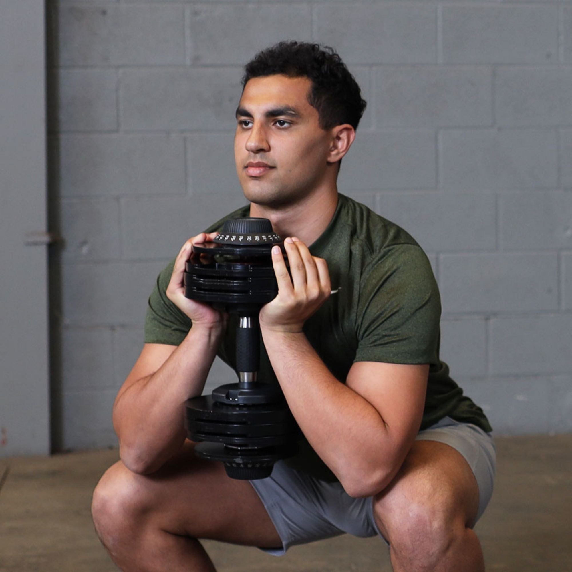 Body-Solid Tools Adjustable Dumbbell Set, 11 lb. to 66 lb. with Stand SDBX132ST Man performing goblet squat with a single adjustable dumbbell