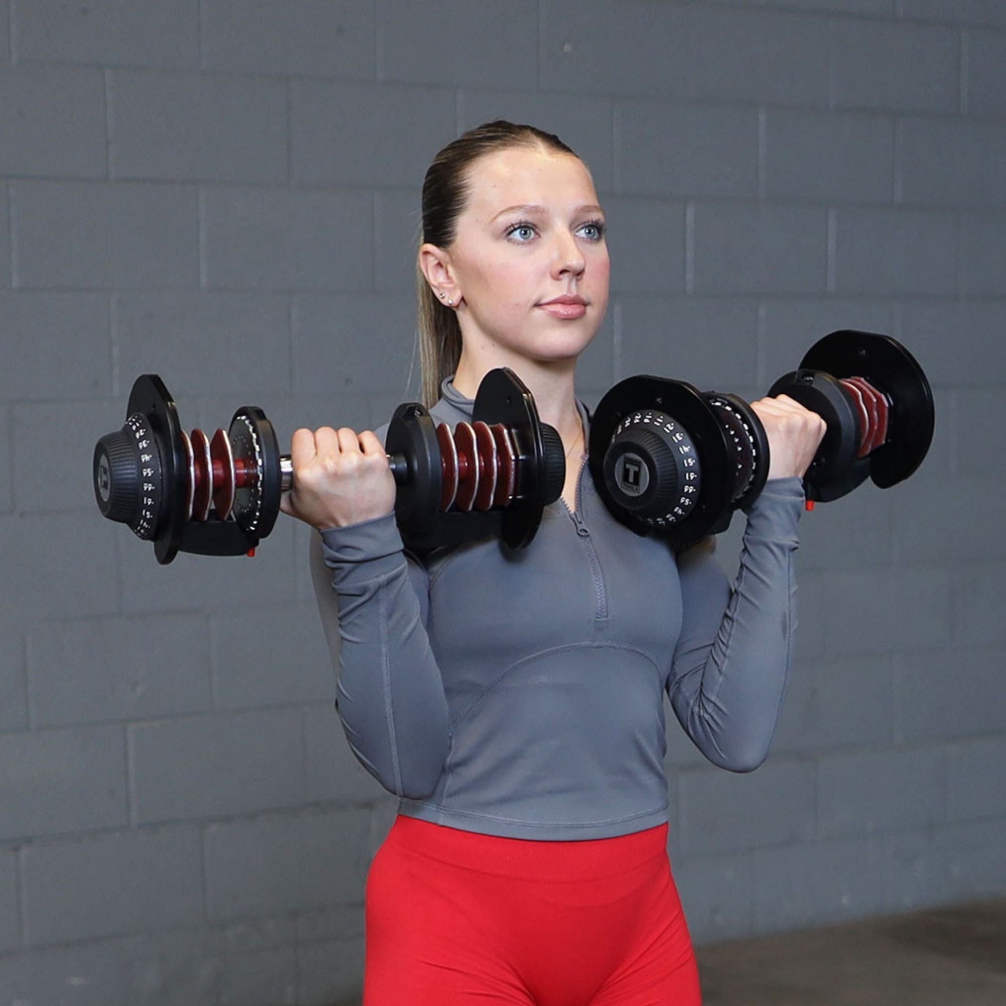 Body-Solid Tools Adjustable Dumbbell Set, 11 lb. to 66 lb. with Stand SDBX132ST Woman performing standing bicep curls with adjustable dumbbells