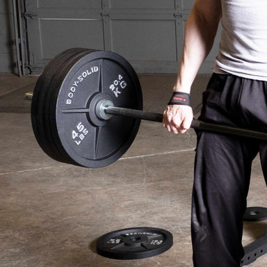 Body-Solid Tools Cast Iron 2" Olympic Plates OSB255 Close-up of athlete lifting barbell loaded with Body-Solid 45 lb Olympic weight plates during strength training.