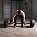 Body-Solid Tools Cast Iron 2" Olympic Plates OSB255 Man preparing for a deadlift using a barbell with multiple Body-Solid Olympic plates in an industrial-style gym.