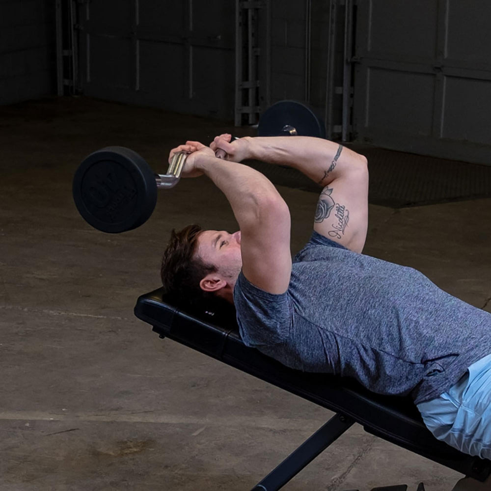 Body-Solid Tools Fixed Weight EZ Curl Barbells, from 20 to 110 lb. Man doing incline tricep extensions using 40 lb curl bar on weight bench