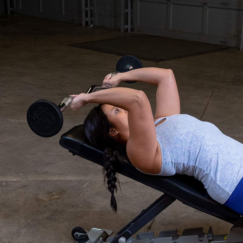 Body-Solid Tools Fixed Weight EZ Curl Barbells, from 20 to 110 lb. Woman performing incline skull crushers with 20 lb EZ curl bar on adjustable bench