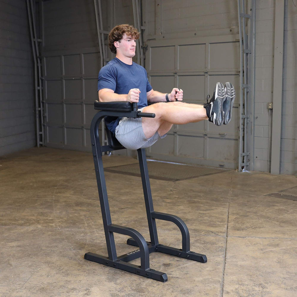 Body-Solid Vertical Knee Raise and Dip GVKR60B Man lifting legs straight while using the Body-Solid VKR station for core strengthening