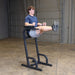 Body-Solid Vertical Knee Raise and Dip GVKR60B Man lifting legs straight while using the Body-Solid VKR station for core strengthening