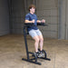 Body-Solid Vertical Knee Raise and Dip GVKR60B Man preparing for knee raises on a Body-Solid vertical knee raise and dip station