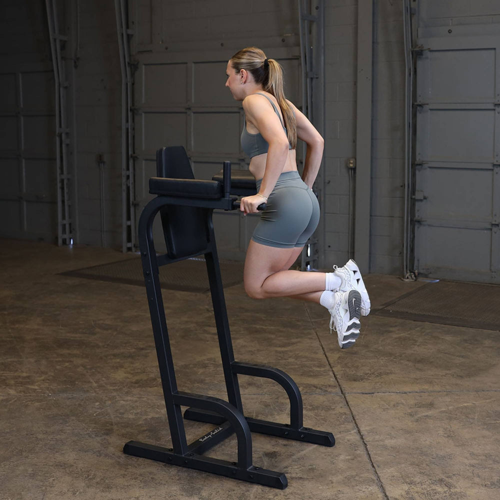 Body-Solid Vertical Knee Raise and Dip GVKR60B Woman executing tricep dips on a Body-Solid vertical knee raise and dip station
