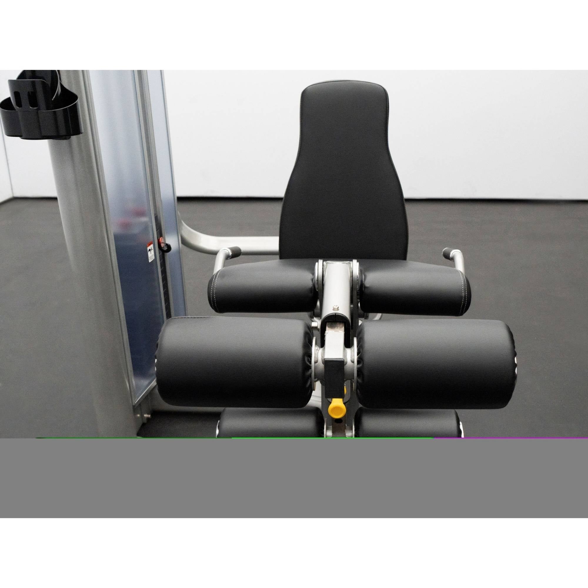 BodyKore Leg Extension/Leg Prone GR643 showing padded rollers, adjustable leg pad, and ergonomic backrest, with part of the weight stack system visible.
