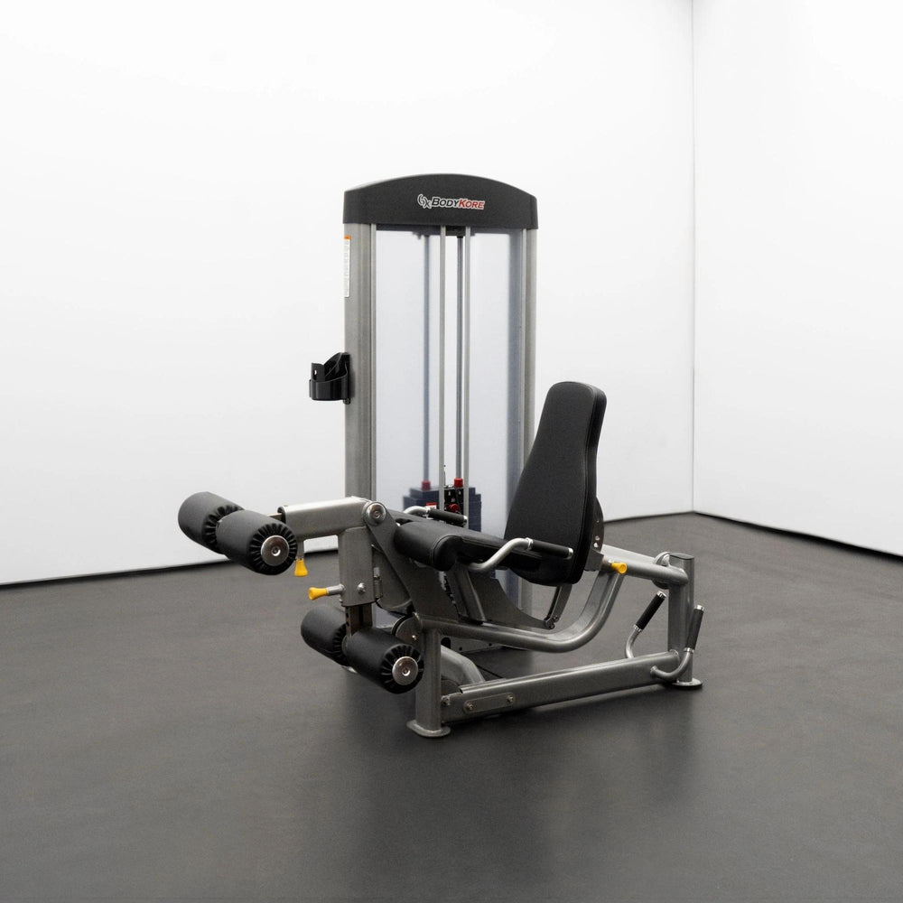 BodyKore Leg Extension/Leg Prone GR643 with padded rollers, adjustable backrest, and integrated weight stack, set in a clean training studio.