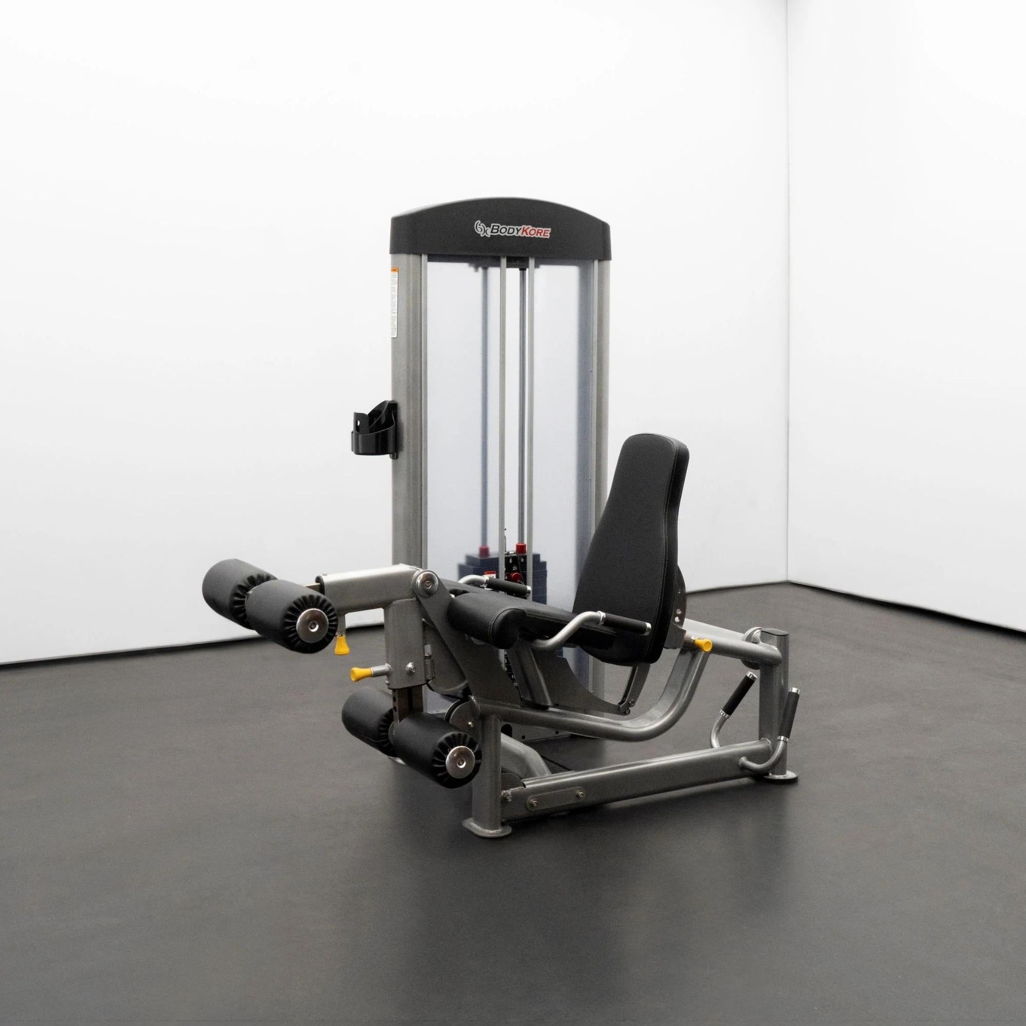 BodyKore Leg Extension/Leg Prone GR643 with padded rollers, adjustable backrest, and integrated weight stack, set in a clean training studio.