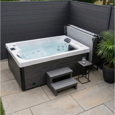 Luxury Spas Cascade LS-790 hot tub with steps and cover placed to the side on a small patio