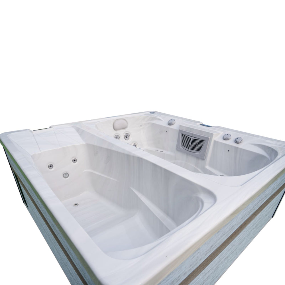 A white double Luxury Spas USA Marquis Hot & Cold Contrast Therapy Spa hot tub with multiple jet nozzles and a vented control panel, shown on a plain white background.