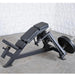 Muscle D weight leverage pec fly bench with a weigh post loaded with black weight plates, set on a gray concrete floor against a white textured wall.