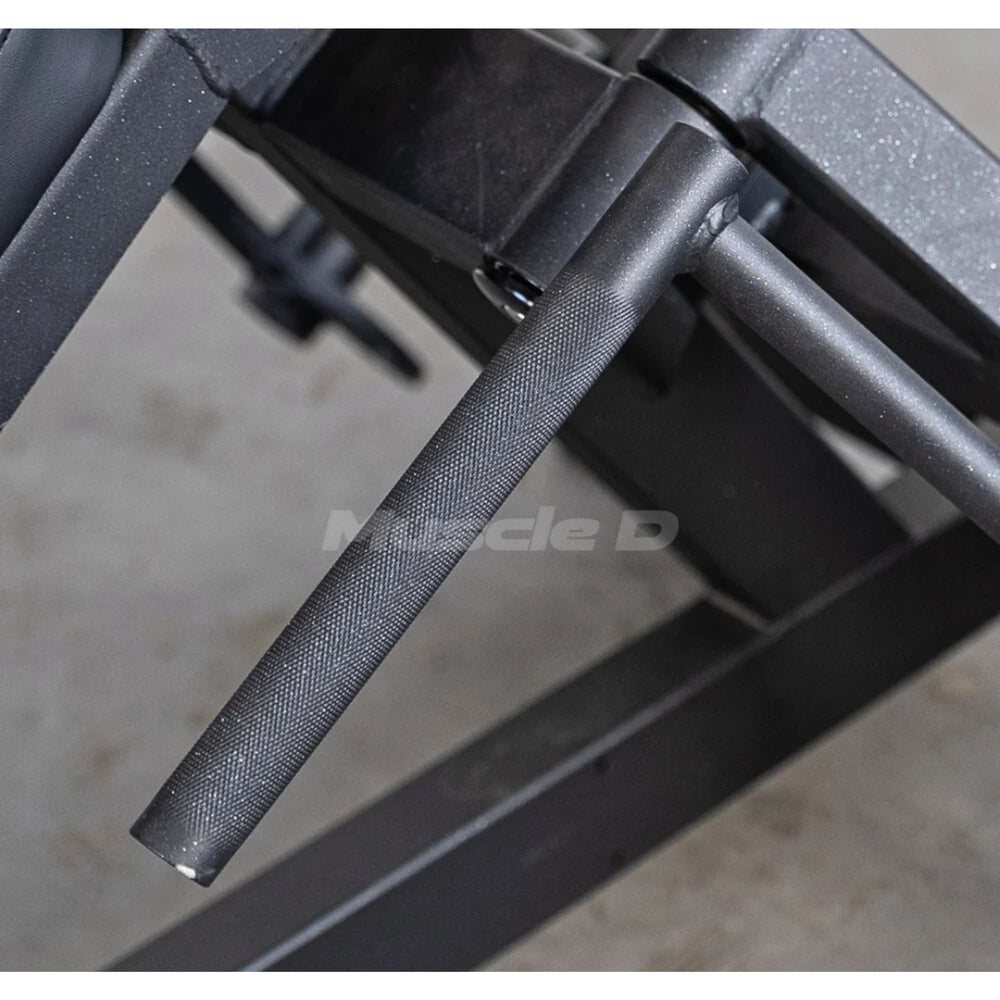 Close-up of a black textured metal barbell or gym accessory attached to a dark steel frame, with a faint Muscle D watermark across the center.