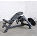 Muscle D weight leverage pec fly bench with padded black seat and backrest, mounted on a dark metal frame with a barbell and weight plate, photographed against a textured white wall and concrete floor.