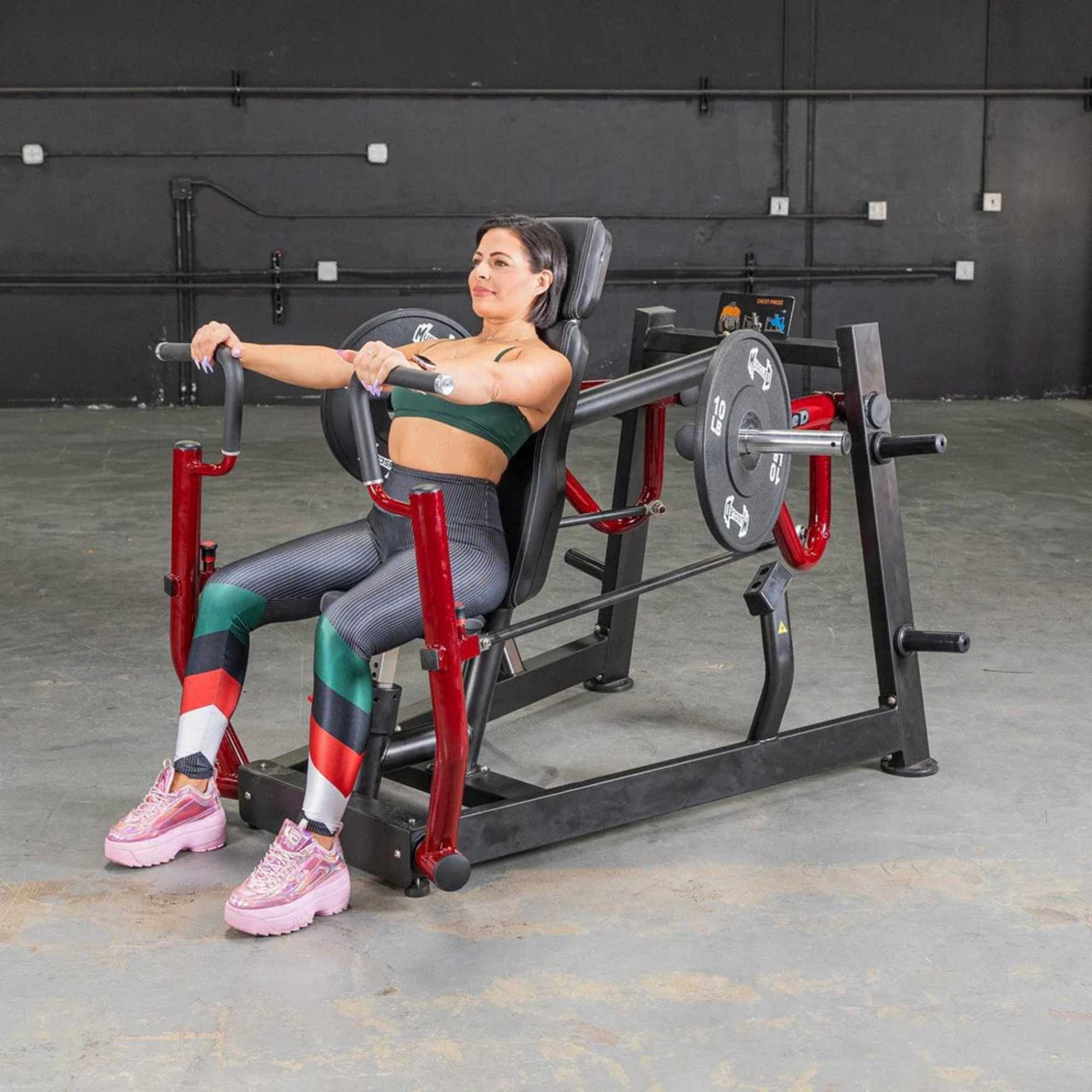 Person performing the chest press on Muscle D Power Leverage V2 Chest Press with 10 lb urethane-coated Olympic plates 