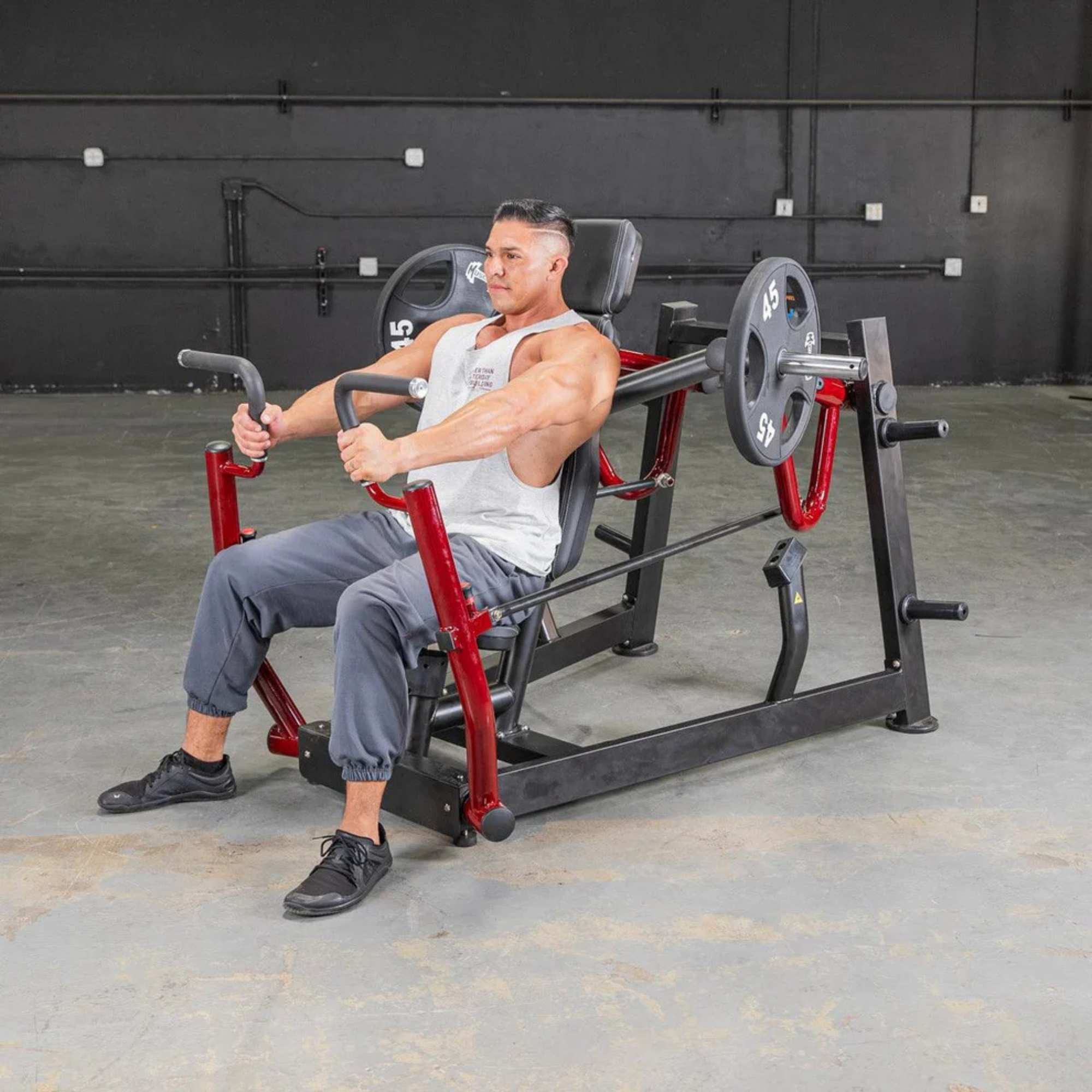 Person performing the chest press on Muscle D  Power Leverage V2 Chest Press with 45 lb urethane-coated Olympic plates 