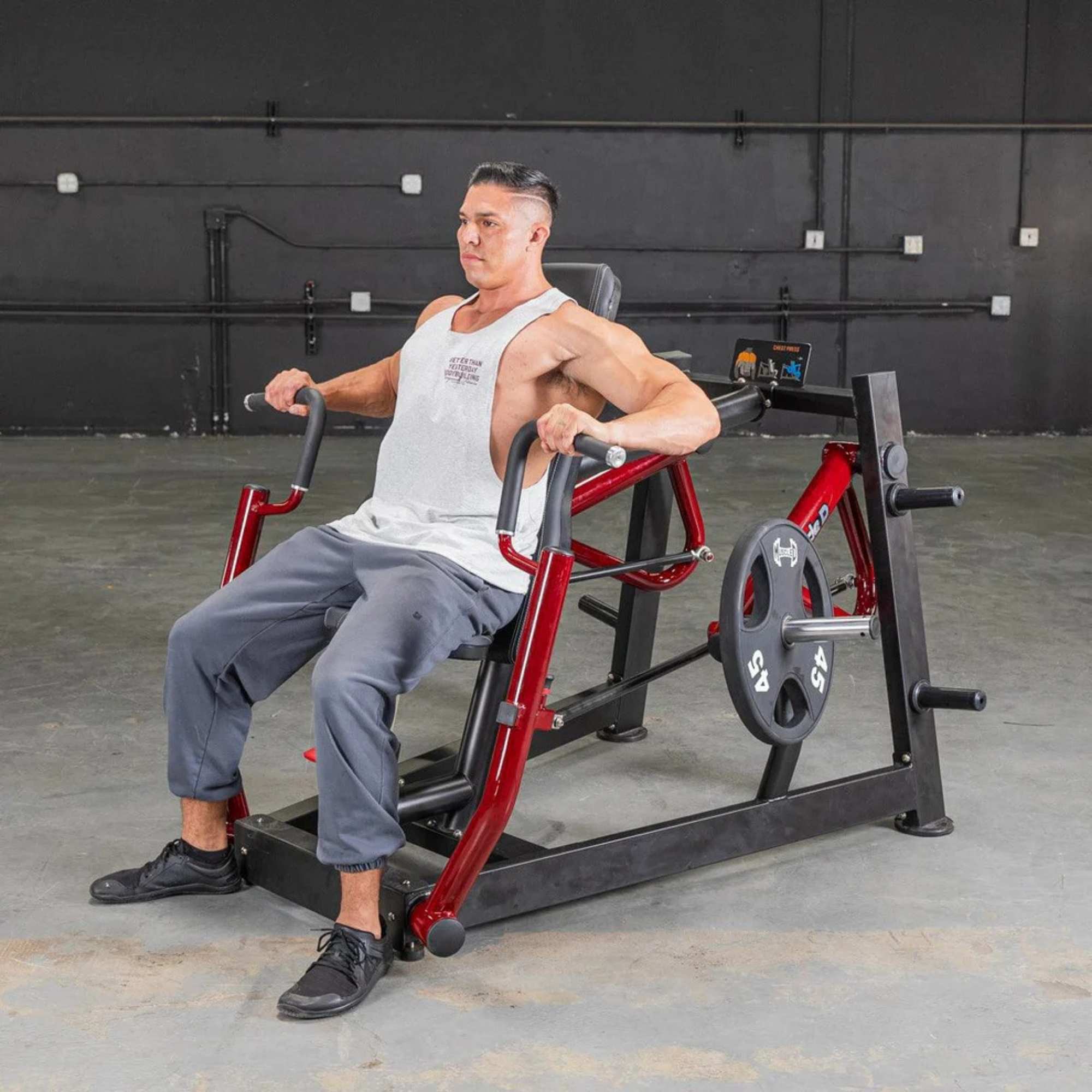 Person performing the chest press on Muscle D Power Leverage V2 Chest Press with 45 lb urethane-coated Olympic plates 