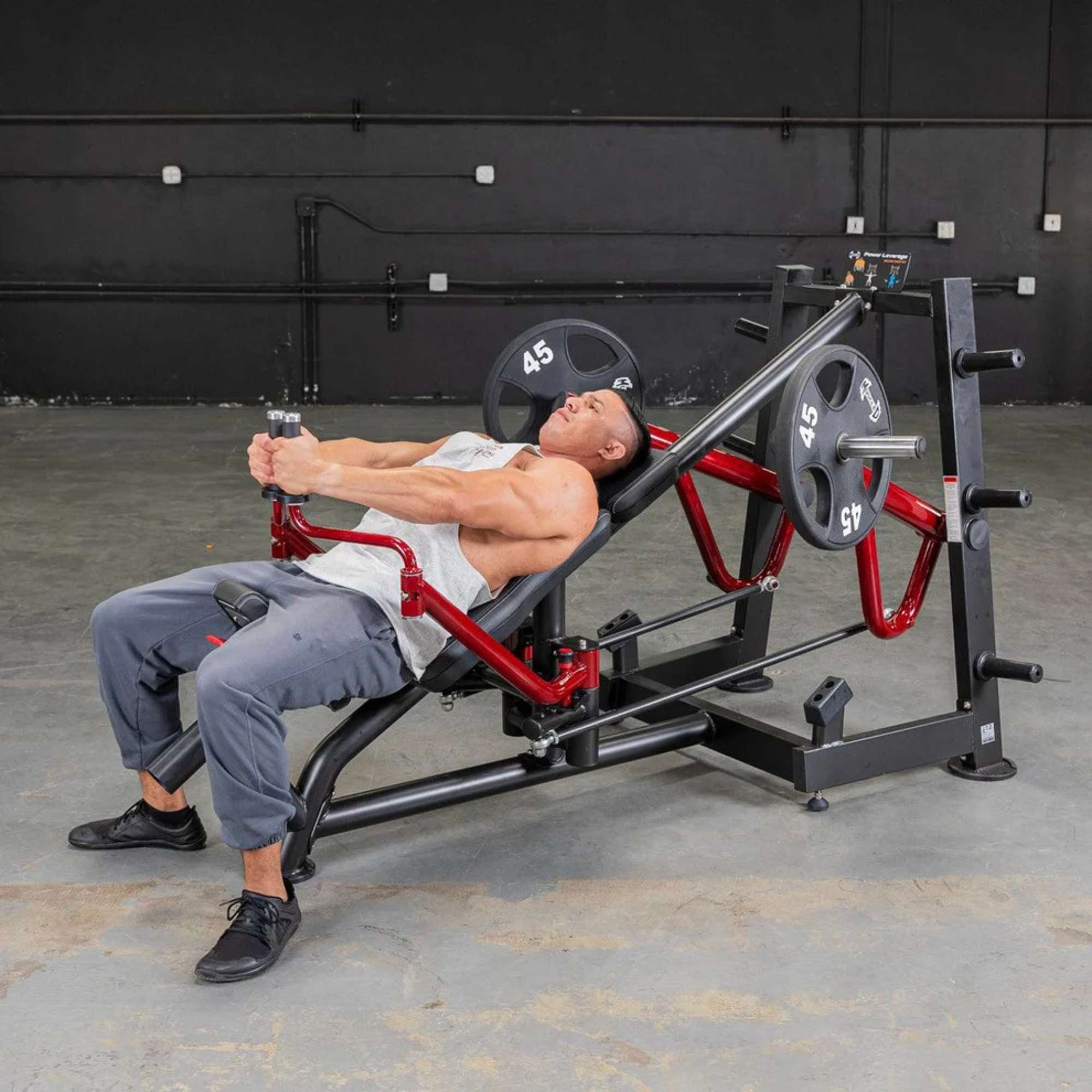 Person performing the chest press on Muscle D Power Leverage V2 Decline Chest Fly / Most Muscular Machine Press with 45 lb urethane-coated Olympic plates 