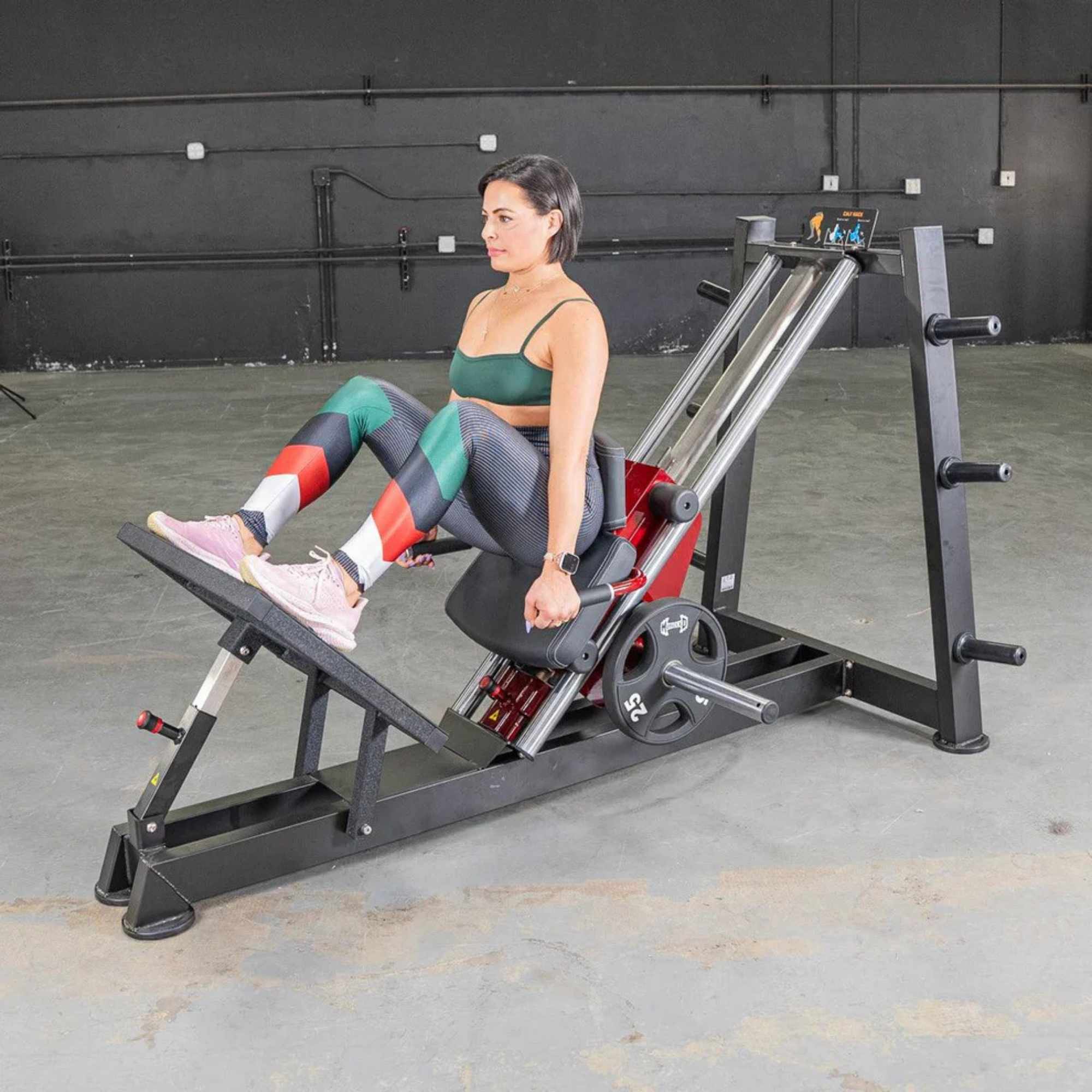 Muscle D Power-Leverage V2 Hack Squat/Calf Raise PL-PV2-HS features a female athlete in a semi-reclined position with their feet placed on the footplate.