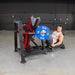 Male athlete executing a 45-degree leg press exercise on the Muscle D Power Leverage V2 machine with a weight-loaded platform.