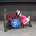 Female athlete demonstrating a leg press workout on the Muscle D Power Leverage V2 machine with 45 lb Olympic plates.