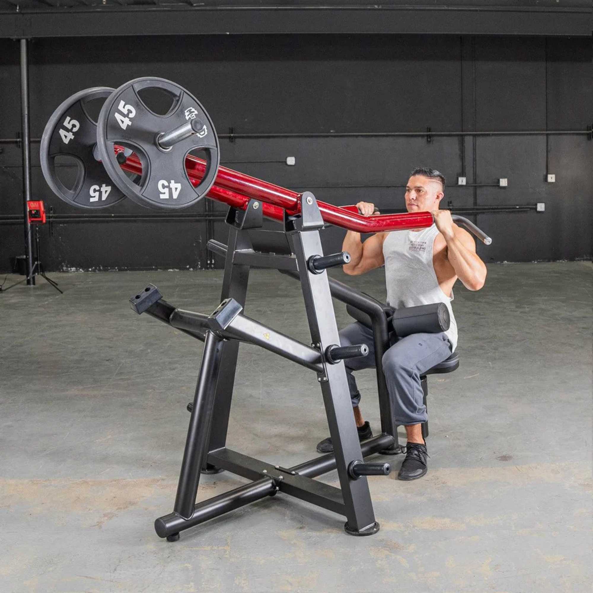 Muscle D Power Leverage V2 Iso-Lateral Lat Pulldown Machine by Muscle D Fitness loaded with 45-lb Olympic plates in use by a male trainer.