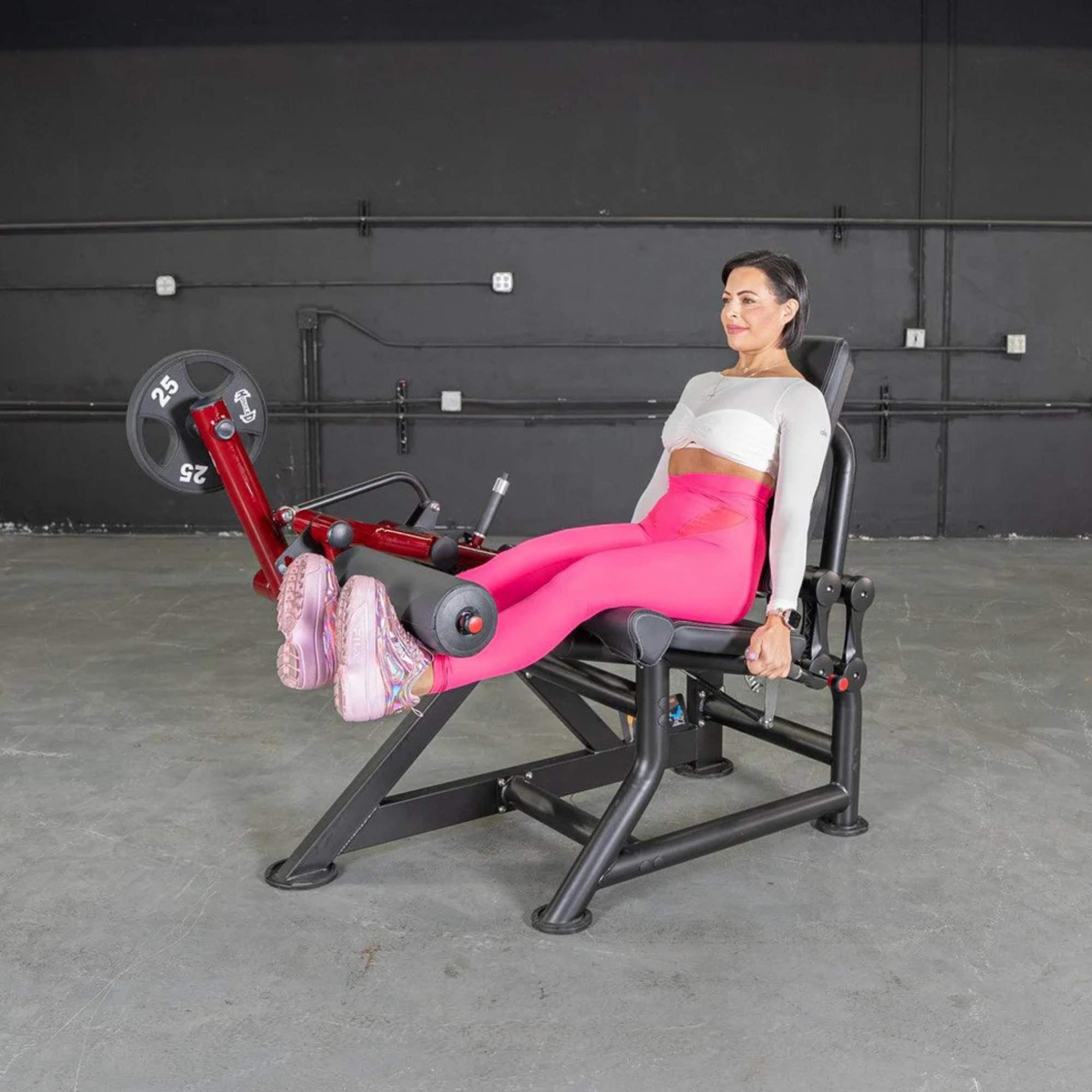 Woman demonstrating Muscle D Power-Leverage V2 Leg Extension, focusing on quad strength with ergonomic padding.