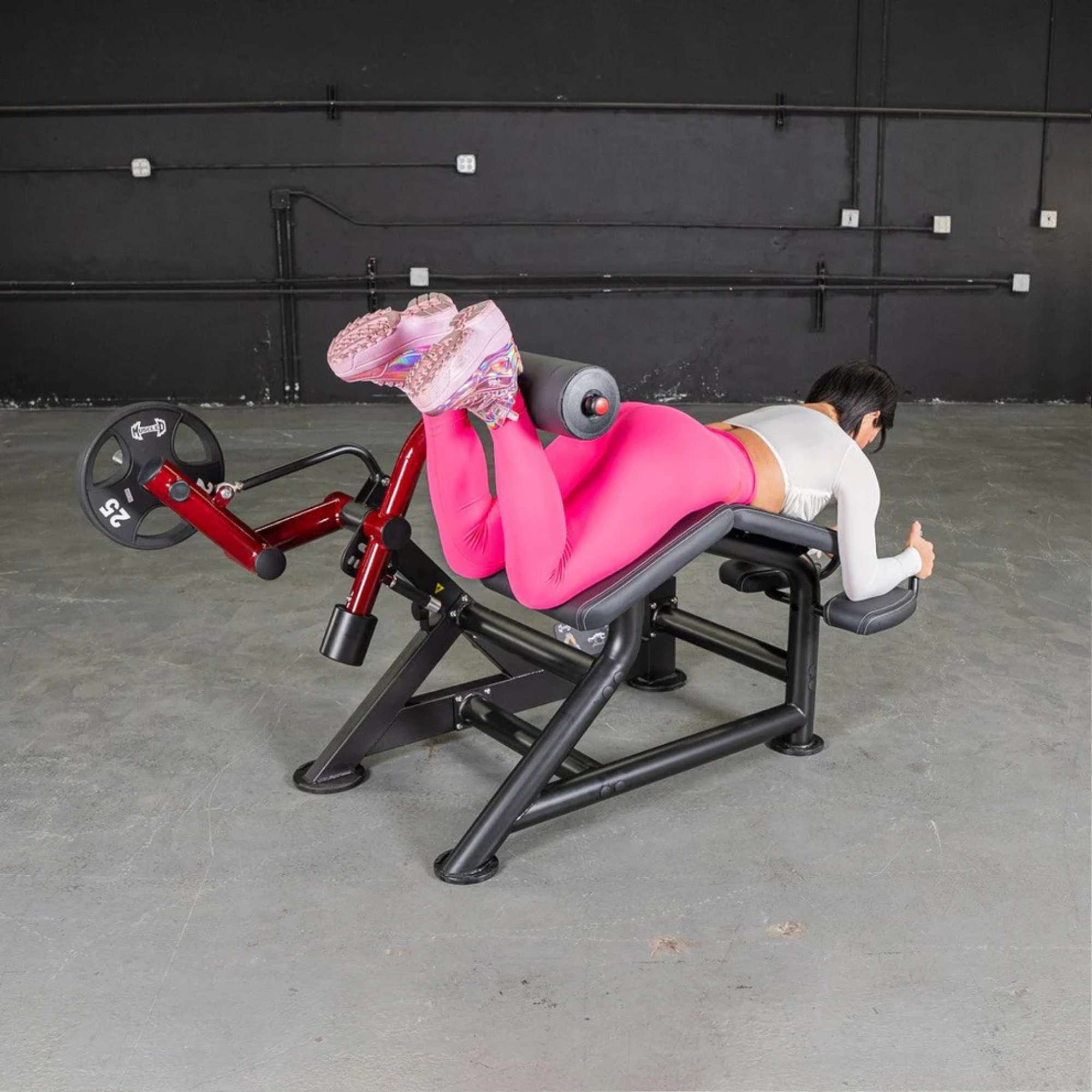 Side view of Muscle D Power Leverage V2 Prone Leg Curl machine showing premium ergonomic design.