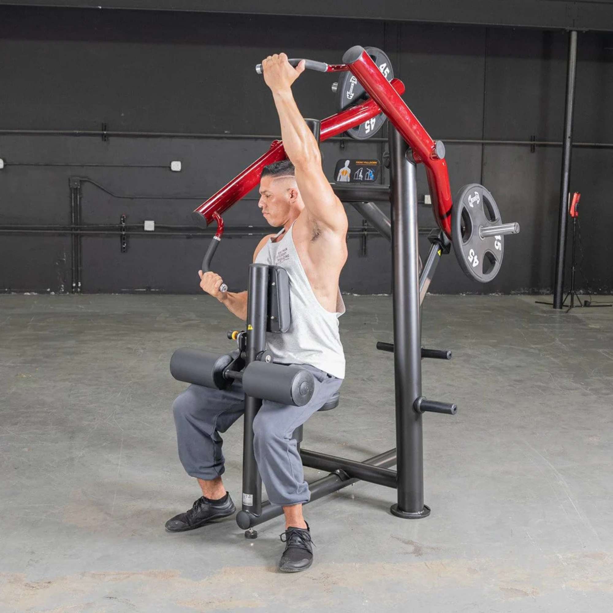 Person using the Muscle D Power Leverage V2 Reverse Grip Lat Pulldown with 45 lb urethane-coated Olympic plates, showing the chest press in action.