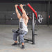 Person using the Muscle D Power Leverage V2 Reverse Grip Lat Pulldown with 45 lb urethane-coated Olympic plates, showing a full body action shot.