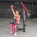 Person performing the exercise on the Muscle D Power Leverage V2 Reverse Grip Lat Pulldown with 25 lb urethane-coated Olympic plates on one side. 