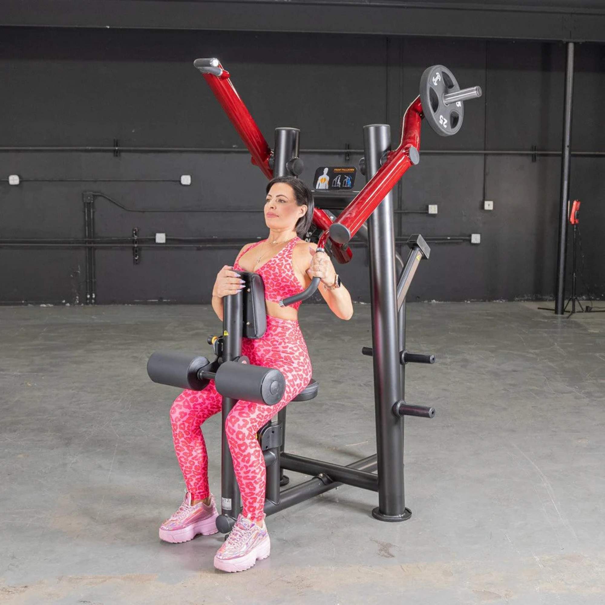 Person performing the exercise on the Muscle D Power Leverage V2 Reverse Grip Lat Pulldown with 25 lb urethane-coated Olympic plates on both sides.