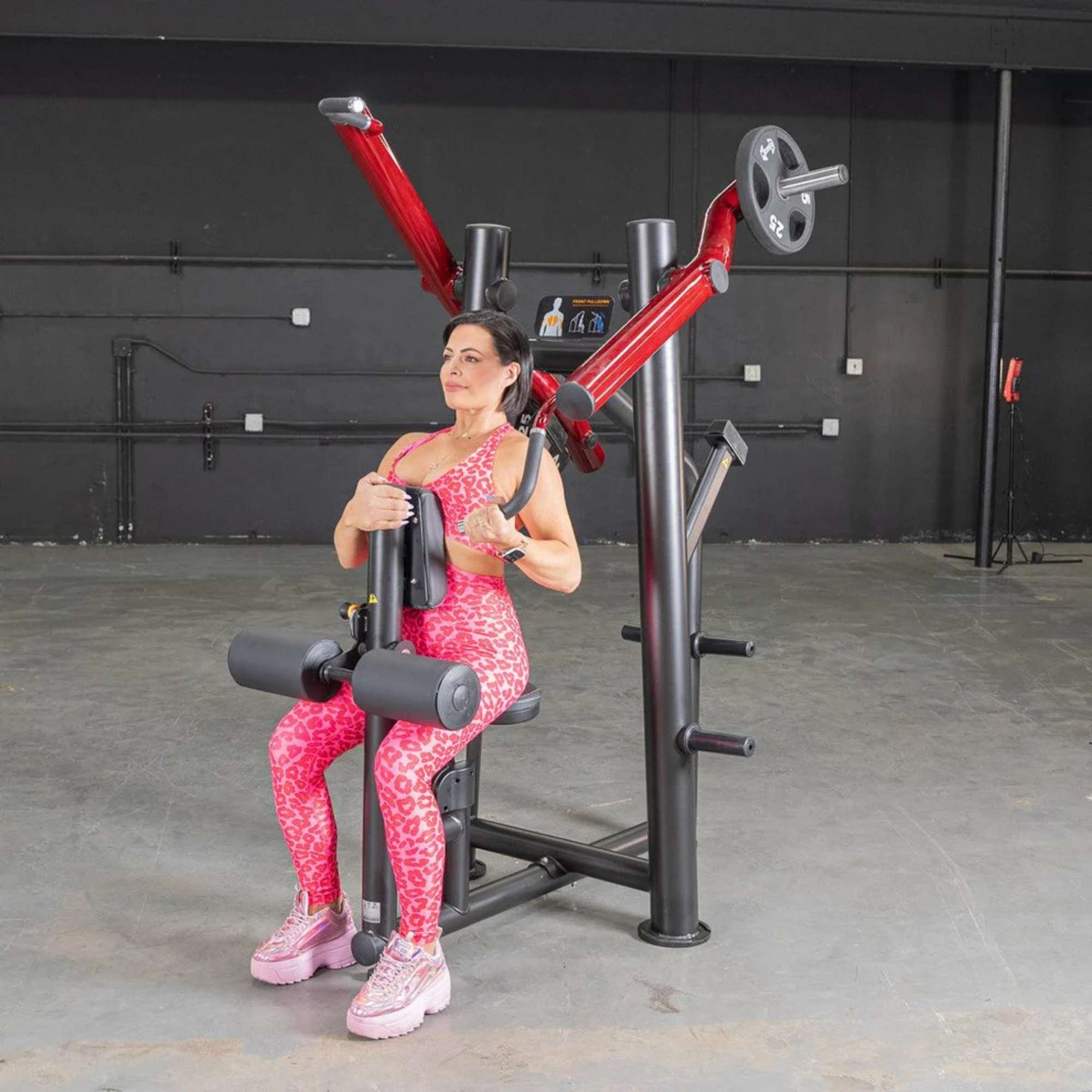 Person performing the exercise on the Muscle D Power Leverage V2 Reverse Grip Lat Pulldown with 25 lb urethane-coated Olympic plates on both sides.