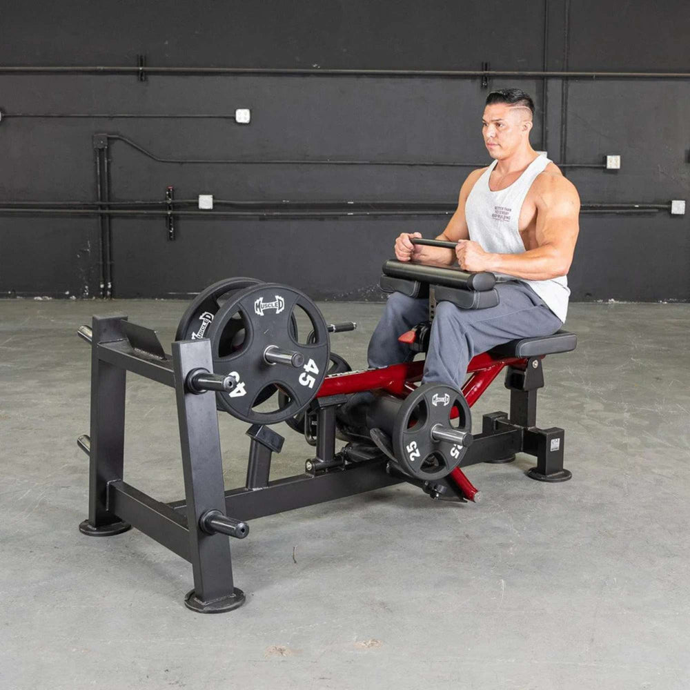Side view of an athlete performing seated calf raises on the Muscle D Power Leverage V2 Seated Calf Tib PL-PV2-SCT machine.