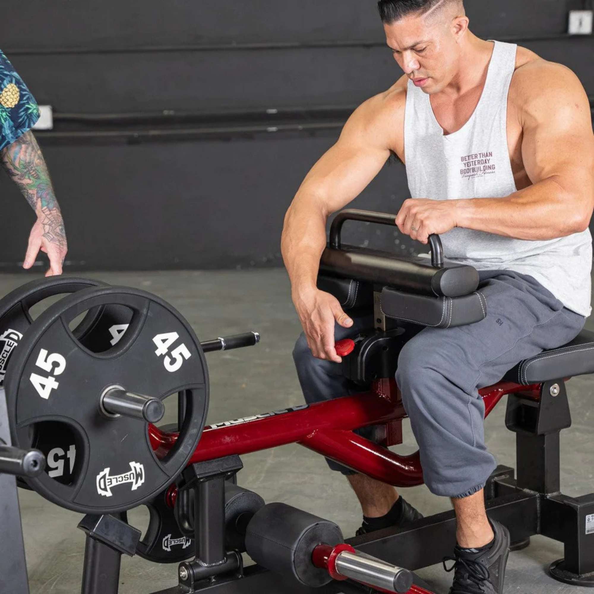 Male athlete adjusting weight settings on the Muscle D Power Leverage V2 Seated Calf Tib PL-PV2-SCT during a seated workout.