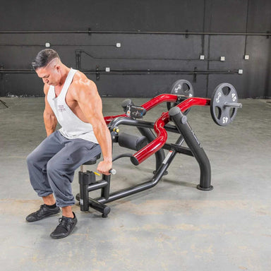 Person using the Muscle D  Power Leverage V2 Seated Dip / Triceps Press  with 45 lb urethane-coated Olympic plates, showing a full body action shot.