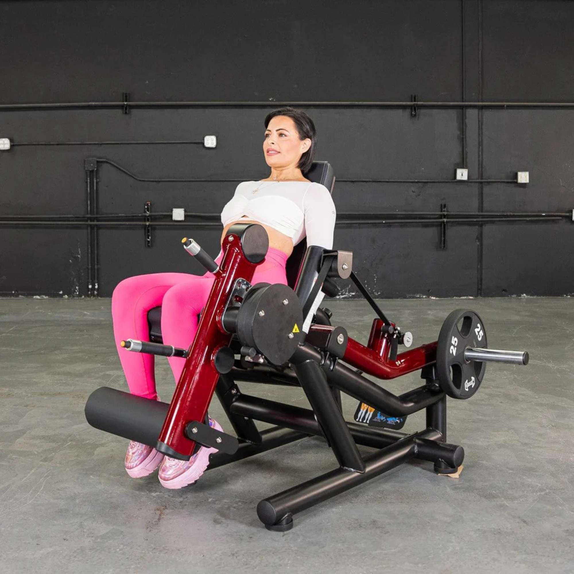 Muscle D  Power Leverage V2 Seated Leg Extension Prone Leg Curl Combo PL-PV2-LELC - Female demonstrating seated leg extension exercise with Olympic plates for lower body strength.