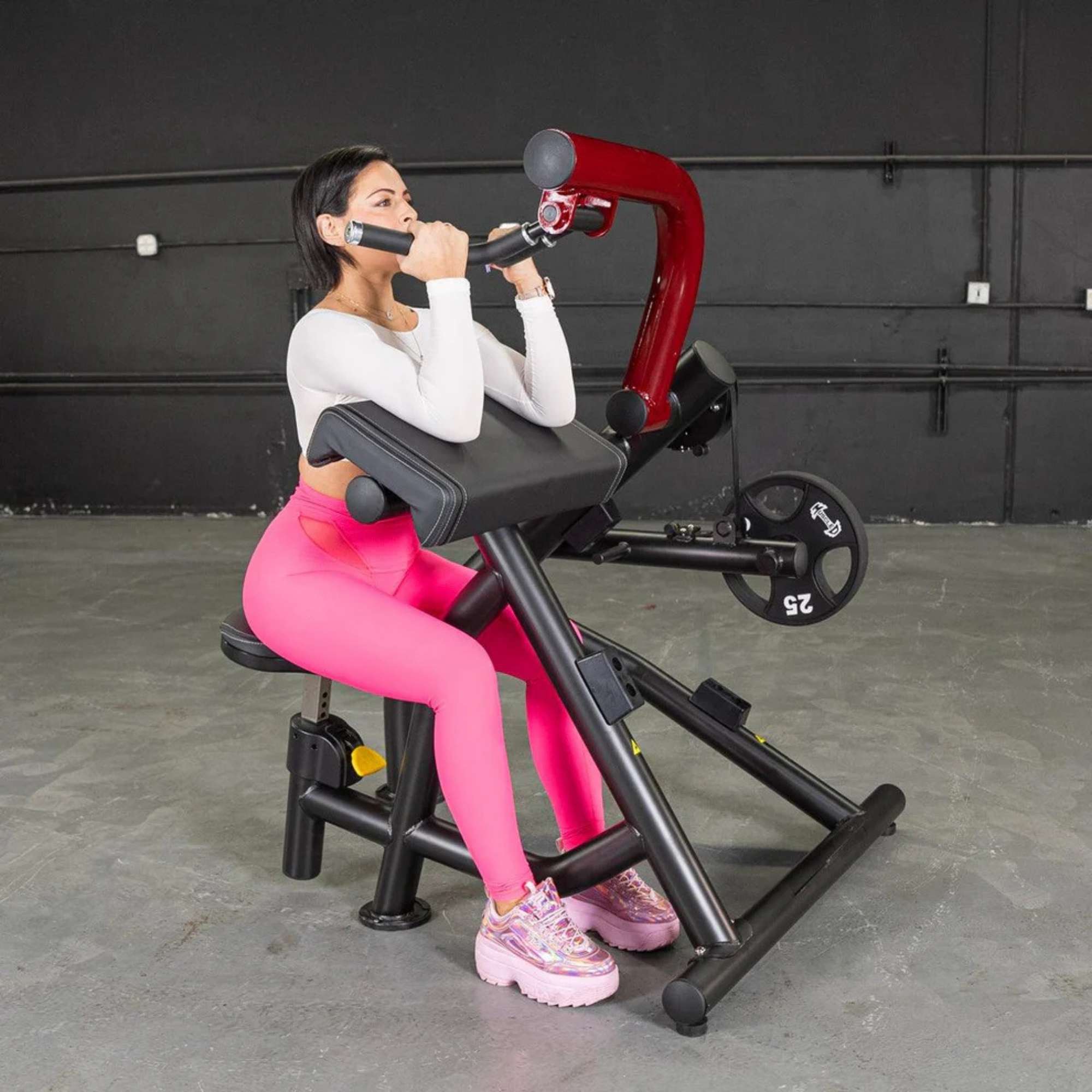 Person using the Muscle D Power Leverage V2 Biceps Curl / Preacher Curl with 25 lb urethane-coated Olympic plates, showing body action shot.