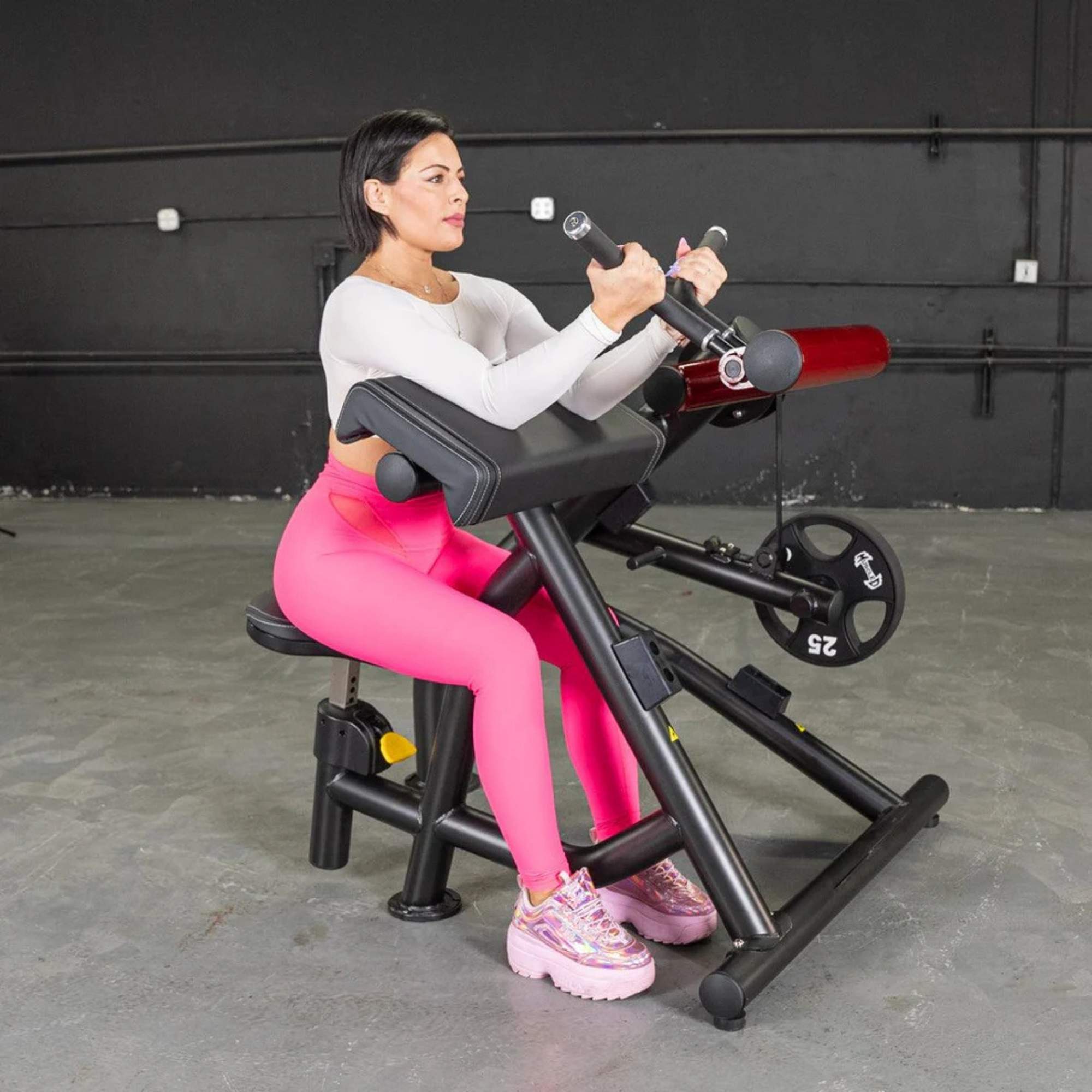 Person using the Muscle D Power Leverage V2 Biceps Curl / Preacher Curl with 25 lb urethane-coated Olympic plates