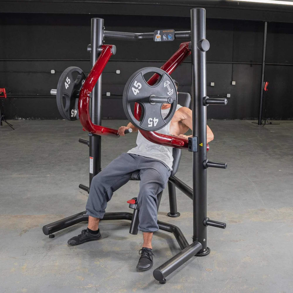 Person using the Power Leverage V2 Decline Chest Press with 45 lb urethane-coated Olympic plates, showing the chest press in action.
